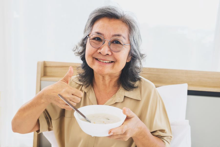 woman eats from a bowl with thumbs up_